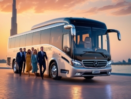 Luxury Mercedes bus with AJEPIC branding parked in front of the Burj Khalifa during sunset.