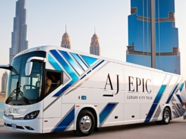 AJ EPIC bus parked near Dubai landmarks in an urban setting